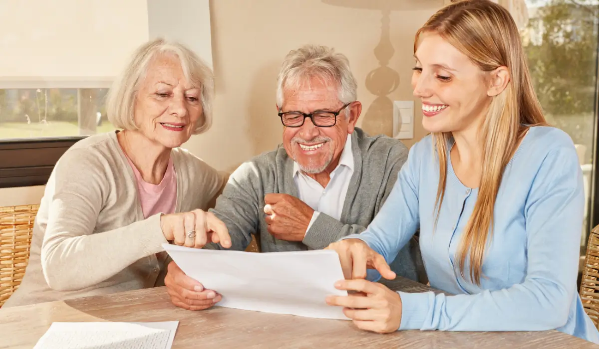 Funeral Beneficiary discussion as senior parents and adult daughter review final expense insurance documents together confidently.